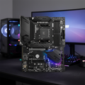 MSI B550 motherboard centered in sharp focus with blurred gaming setup background.