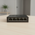 TP-Link LS1005G compact gigabit switch on a clean tabletop.