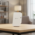 TP-Link RE330 WiFi extender placed on a real home surface in a natural indoor setup.